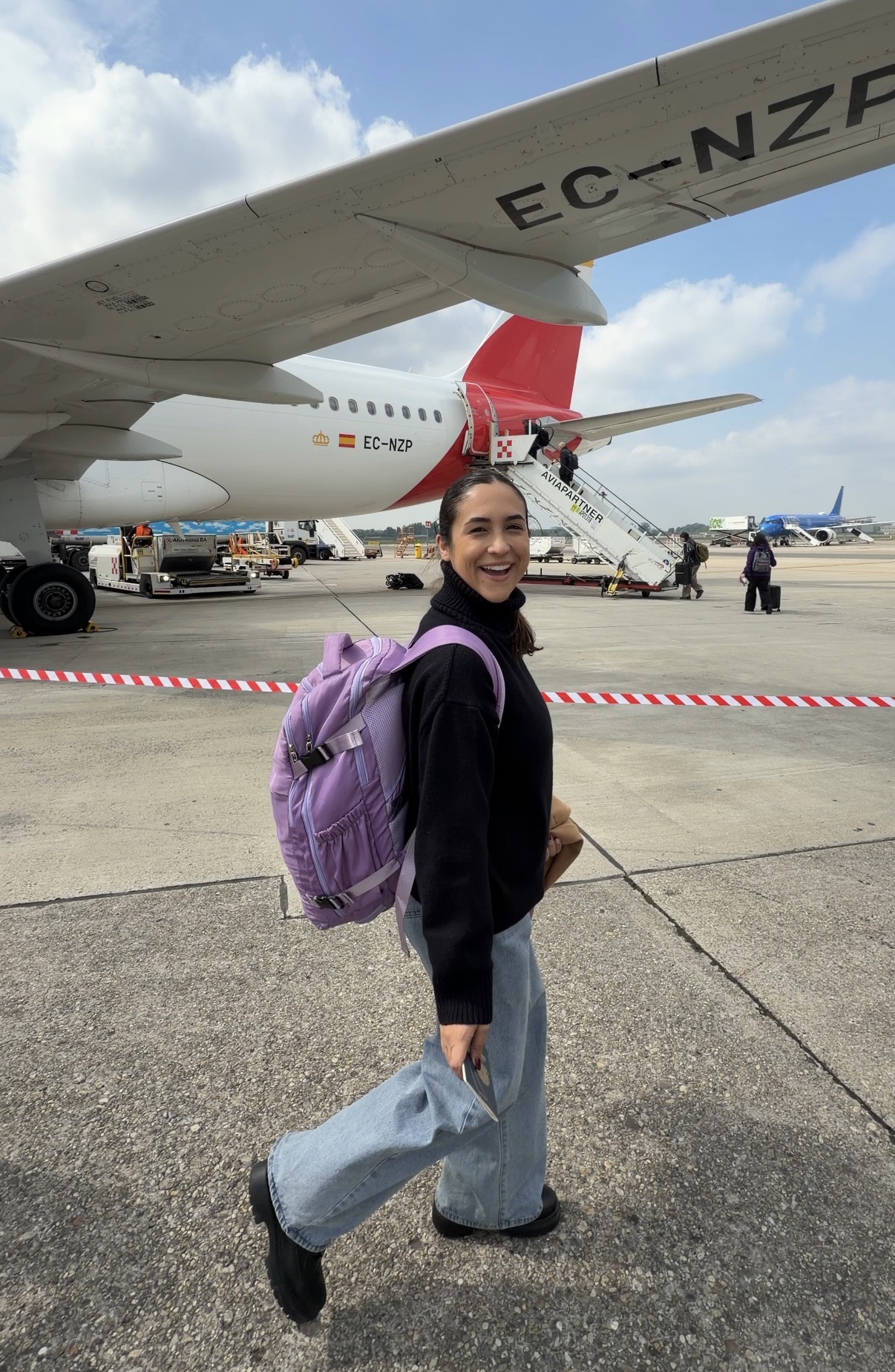 Mari em viagem ao lado de um avião